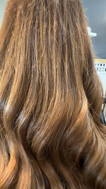 Glossy warm brunette waves created at Elisa’s Hair Studio